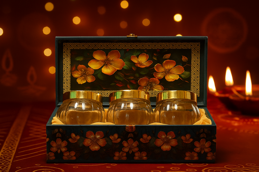 Decorative box with three glass jars inside, set against a warm, blurred background with lights.